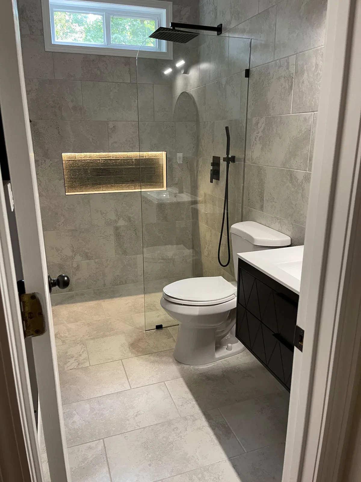 Modern bathroom with marble tiles and frameless shower